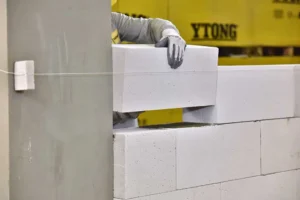 Bir inşaat işçisi Ytong gazbeton bloklarla duvar örerken.
