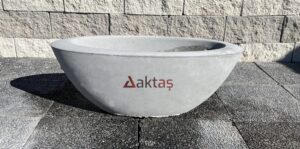80x30x30 cm boyutlarında, üzerinde Aktaş logosu bulunan gri renkli beton kayık saksı. Dış mekan kullanımı için ideal.