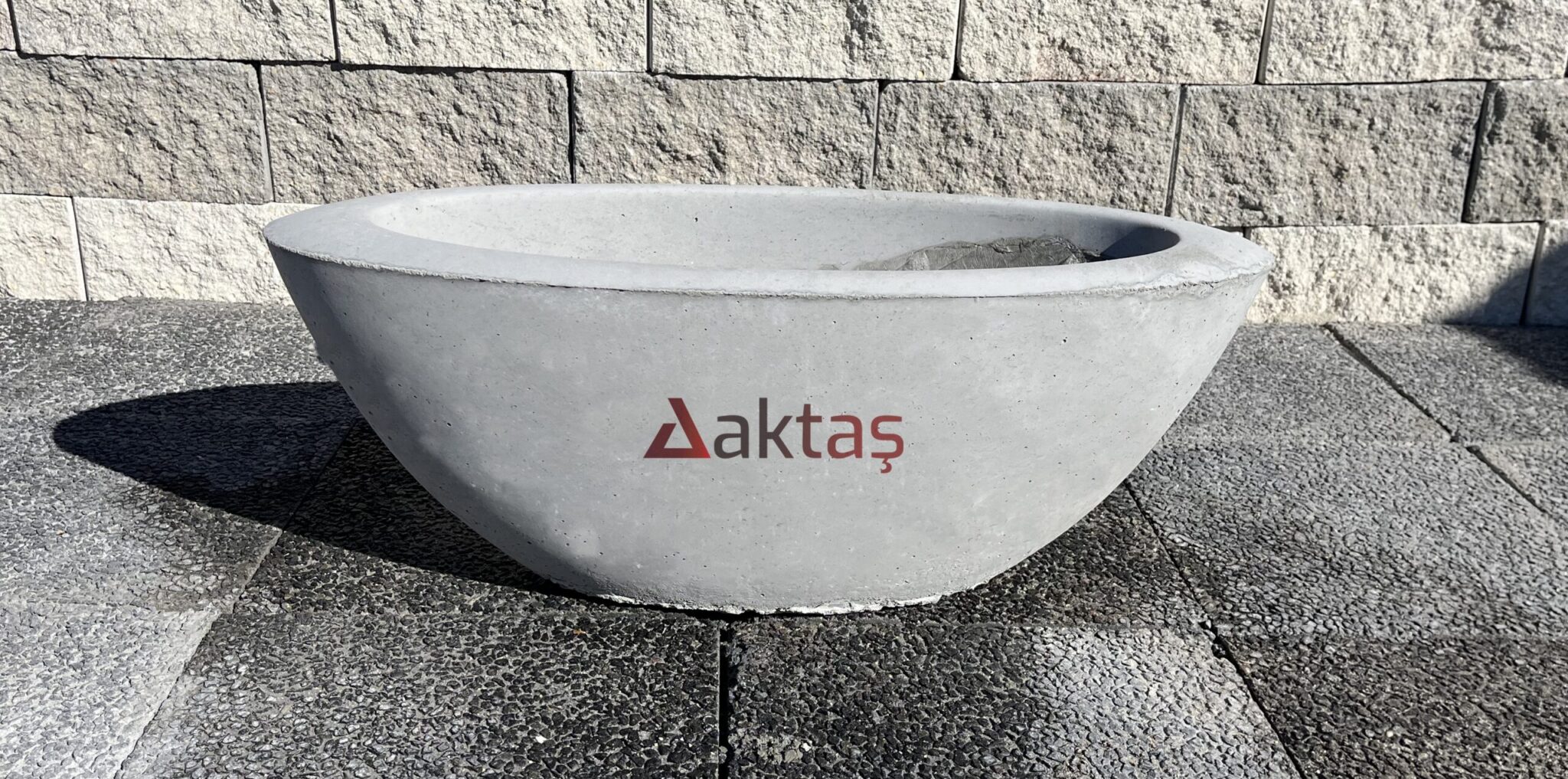 80x30x30 cm boyutlarında, üzerinde Aktaş logosu bulunan gri renkli beton kayık saksı. Dış mekan kullanımı için ideal.