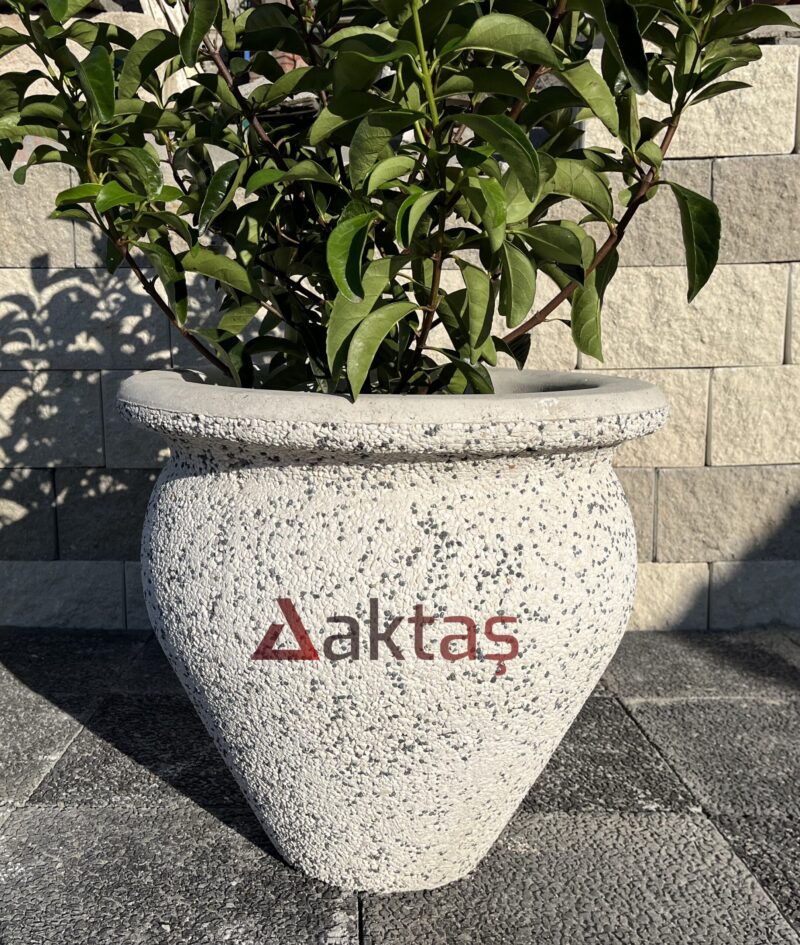 50x50x50 cm boyutlarında, beyaz mozaik dokulu vazo şeklinde beton saksı içinde yeşil yapraklı bir bitki ile dış mekanda kullanılmış hali.