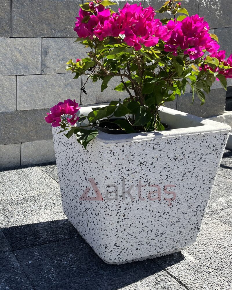 40x40x44 cm boyutlarında, beyaz mozaik dokulu kare beton saksı içinde canlı pembe çiçekli bitki ile dış mekanda kullanılmış hali.