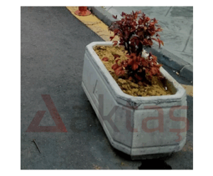 80x40x40 cm boyutlarında, üzerinde Aktaş logosu bulunan doğal gri renkte dikdörtgen beton saksı. İçinde kırmızı yapraklı bir bitki ile dış mekanda kullanılmış hali.