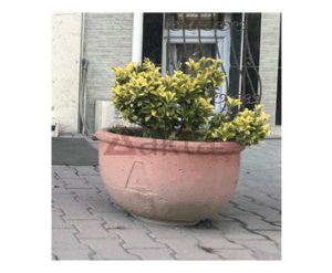60x60x44 cm boyutlarında, üzerinde Aktaş logosu bulunan doğal gri renkte yuvarlak beton saksı. İçinde gür yeşil bir bitki ile dış mekanda kullanılmış hali.