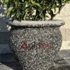 50x50x50 cm boyutlarında, siyah mozaik dokulu vazo şeklinde beton saksı içinde yeşil yapraklı bir bitki ile dış mekanda kullanılmış hali.