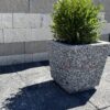 40x40x44 cm boyutlarında, siyah mozaik dokulu kare beton saksı içinde yeşil bitki ile dış mekanda kullanılmış hali.